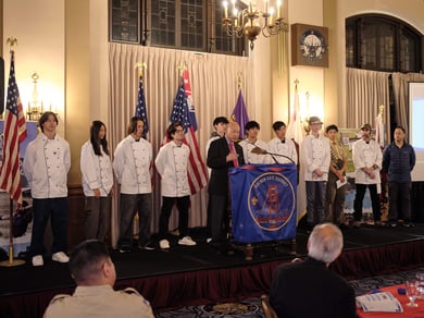 Crew 21 on stage in chef outfits at Golden Gate District volunteer recognition dinner 2025
