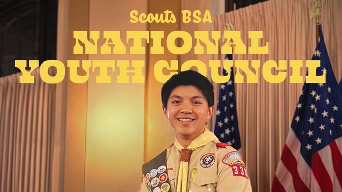 Scout smiling at camera with the text "Scouts BSA National Youth Council" above him